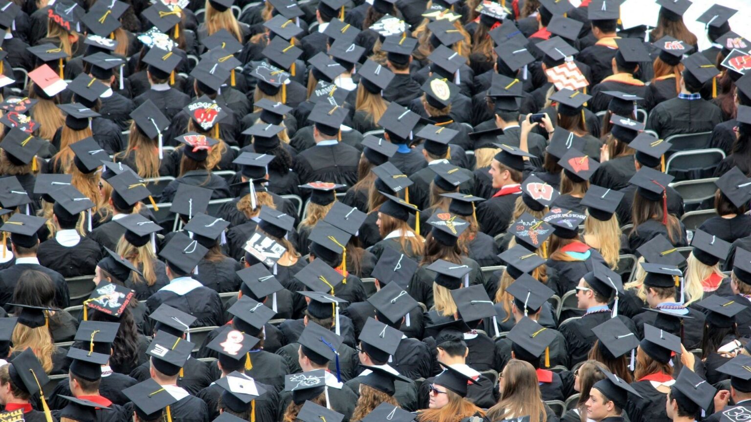 New Grads Blame AI for a Tough Job Market, But Experts Point to a Much Bigger Shortage Coming A sea of graduates in caps and gowns during the commencement ceremony.