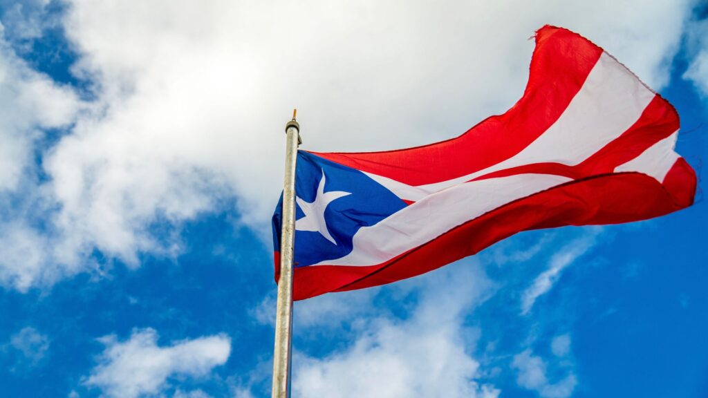 Puerto Rico flag waving against blue sky.