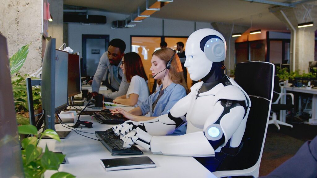 Humanoid robot working alongside human employees in a modern office.