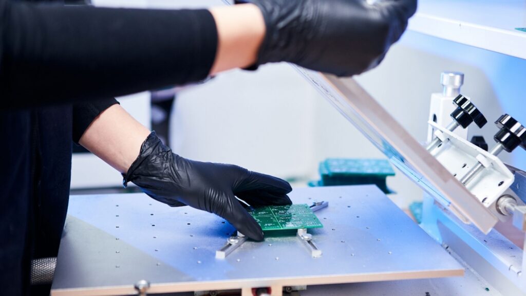 An engineer factory worker works with electronics on a chip.