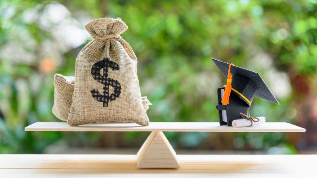 Scale balancing money bags and a graduation cap.